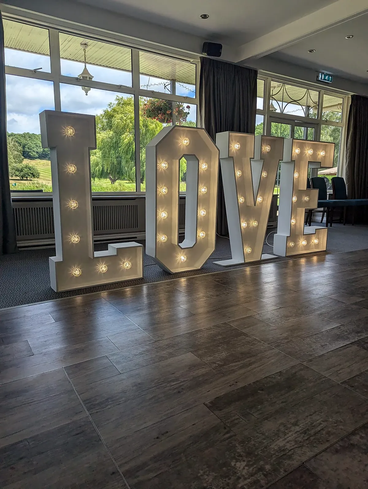 Illuminated surname letters forming a wedding photo feature in Weybridge